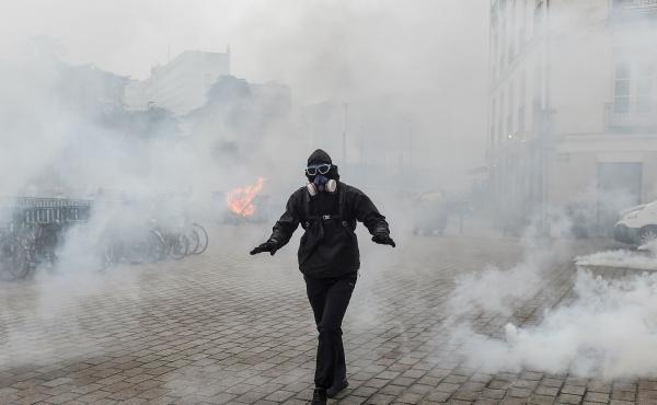 A protester walks through a cloud of tear gas during a demonstration against national pension changes in Nantes, France, on Thursday. A protester walks through a cloud of tear gas during a demonstration against national pension changes in Nantes, France, on Thursday.