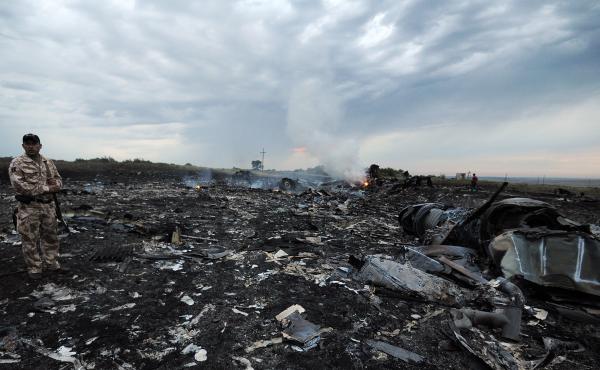 A man wearing military fatigues stands next to the wreckage of Malaysia Airlines MH17 carrying 298 passengers and crew, that crashed in eastern Ukraine six years ago. A man wearing military fatigues stands next to the wreckage of Malaysia Airlines MH17 carrying 298 passengers and crew, that crashed in eastern Ukraine six years ago.