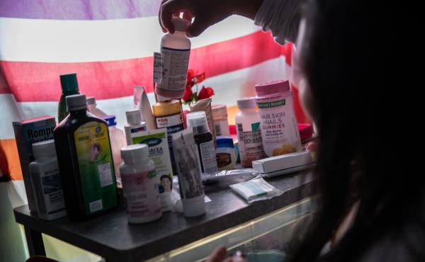 A woman recovering from fever linked to COVID-19 checks medications in her home in Mineola, N.Y., this spring. A woman recovering from fever linked to COVID-19 checks medications in her home in Mineola, N.Y., this spring.