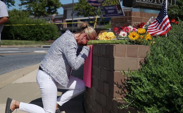 Lynne Griffin pays her respects at a makeshift memorial outside the Capital Gazette offices, one day after a gunman killed five people in its newsroom. Griffin was a journalism student under John McNamara — one of the people killed Thursday. Lynne Griffin pays her respects at a makeshift memorial outside the Capital Gazette offices, one day after a gunman killed five people in its newsroom. Griffin was a journalism student under John McNamara — one of the people killed Thursday.