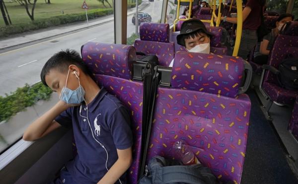 Passengers sleep on the upper deck of a double-decker bus in Hong Kong on Saturday. Passengers sleep on the upper deck of a double-decker bus in Hong Kong on Saturday.