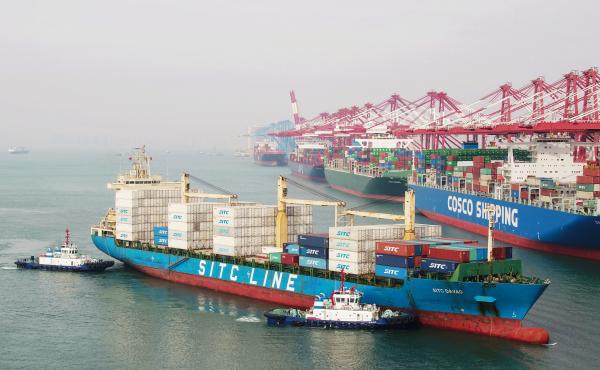 A cargo ship prepares to berth at a port in Qingdao in China's eastern Shandong province on Wednesday. New tariffs went into effect Friday. A cargo ship prepares to berth at a port in Qingdao in China's eastern Shandong province on Wednesday. New tariffs went into effect Friday.
