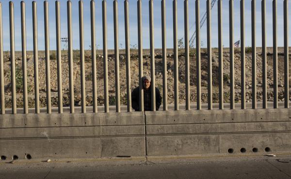 Issac Rodriguez, from Sinaloa, Mexico, peering through the fence that divides Mexico and the U.S. in Tijuana, Mexico. Issac Rodriguez, from Sinaloa, Mexico, peering through the fence that divides Mexico and the U.S. in Tijuana, Mexico.
