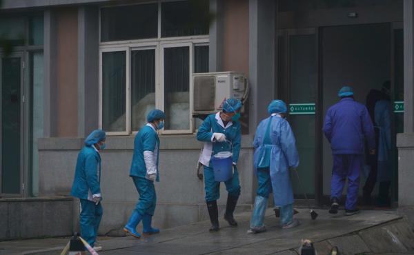 Hospital staff wash the emergency entrance of Wuhan Medical Treatment Center, where patients infected with a new virus are being treated, in Wuhan, China, on Wednesday. Hospital staff wash the emergency entrance of Wuhan Medical Treatment Center, where patients infected with a new virus are being treated, in Wuhan, China, on Wednesday.