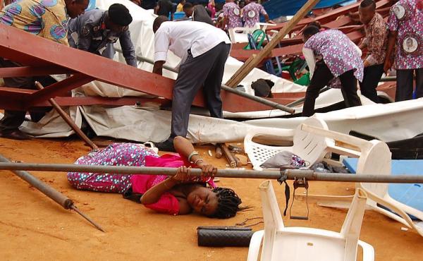 A woman lies under a scaffolding bar Saturday after the collapse at a church in the remote southeastern city of Uyo, the capital of Nigeria's Akwa Ibom state. A woman lies under a scaffolding bar Saturday after the collapse at a church in the remote southeastern city of Uyo, the capital of Nigeria's Akwa Ibom state.