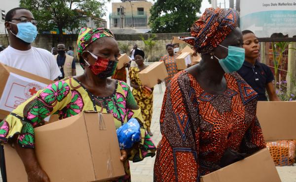 People collect emergency rations of food and essential supplies from the Red Cross Society of Nigeria in Lagos State earlier this week. People collect emergency rations of food and essential supplies from the Red Cross Society of Nigeria in Lagos State earlier this week.