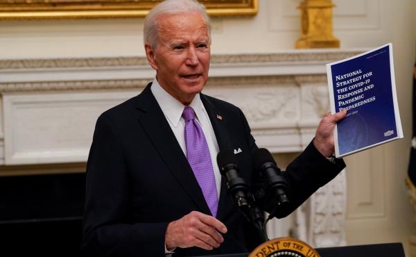 President Joe Biden holds a booklet as he speaks about the coronavirus in the State Dining Room of the White House, Thursday. President Joe Biden holds a booklet as he speaks about the coronavirus in the State Dining Room of the White House, Thursday.