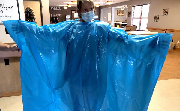 Kelly Womochil, an aide at Enterprise Estates Nursing Center in Enterprise, Kan., tries on a poncho that the Federal Emergency Management Agency is sending to nursing homes to protect against the coronavirus. Kelly Womochil, an aide at Enterprise Estates Nursing Center in Enterprise, Kan., tries on a poncho that the Federal Emergency Management Agency is sending to nursing homes to protect against the coronavirus.