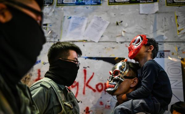 A police officer stares down a man and child wearing masks in the Lan Kwai Fong area of central Hong Kong. A police officer stares down a man and child wearing masks in the Lan Kwai Fong area of central Hong Kong.