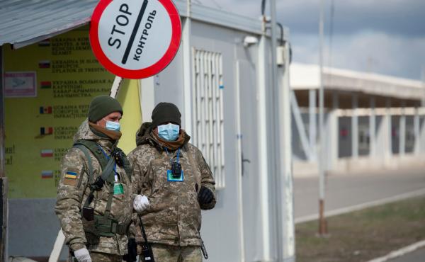 Ukrainian border guards wear protective face masks at a checkpoint with the territories controlled by Russia-backed separatists in the Donetsk region. Ukrainian border guards wear protective face masks at a checkpoint with the territories controlled by Russia-backed separatists in the Donetsk region.