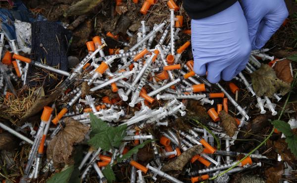A volunteer cleans up needles used for drug injection that were found at a homeless encampment in Everett, Wash., in November. Respondents in a Federal Reserve survey who knew someone who had been addicted to opioids were less likely to give the economy a A volunteer cleans up needles used for drug injection that were found at a homeless encampment in Everett, Wash., in November. Respondents in a Federal Reserve survey who knew someone who had been addicted to opioids were less likely to give the economy a