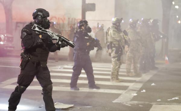 Federal officers deploy tear gas and crowd control munitions at demonstrators during a Black Lives Matter protest Tuesday at the Mark O. Hatfield U.S. Courthouse in Portland, Ore. Federal officers deploy tear gas and crowd control munitions at demonstrators during a Black Lives Matter protest Tuesday at the Mark O. Hatfield U.S. Courthouse in Portland, Ore.