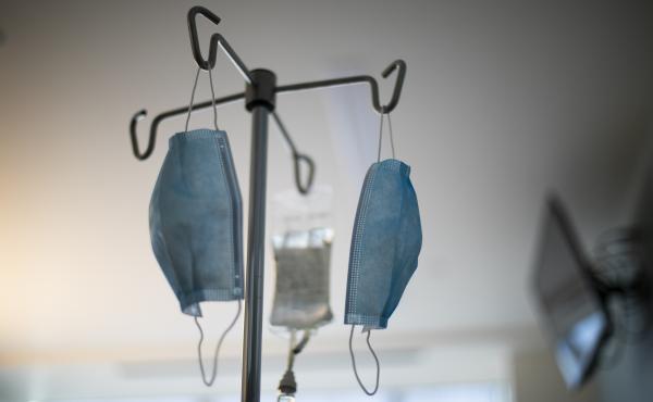 Masks hang from an IV pole at a hospital. Masks hang from an IV pole at a hospital.