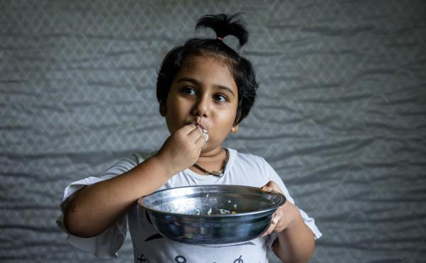 Hosna Ali, 6, eats rice with dried fish at home in Seleyang, Malaysia. Her dad, Mohd Ali, says the family has not been getting enough nutrients during the pandemic. Hosna Ali, 6, eats rice with dried fish at home in Seleyang, Malaysia. Her dad, Mohd Ali, says the family has not been getting enough nutrients during the pandemic.