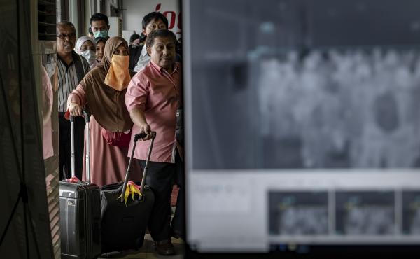 Passengers from an international flight have their temperature checked as they pass a thermal scanner monitor, seen at right, upon arrival at the international Airport in Yogyakarta, Indonesia on Thursday. Passengers from an international flight have their temperature checked as they pass a thermal scanner monitor, seen at right, upon arrival at the international Airport in Yogyakarta, Indonesia on Thursday.