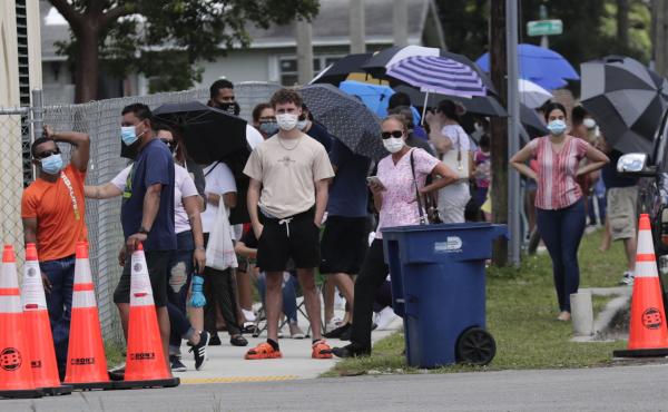 People wait in line outside a testing site in Florida. The state has seen unprecedented surges in coronavirus cases in recent weeks. People wait in line outside a testing site in Florida. The state has seen unprecedented surges in coronavirus cases in recent weeks.