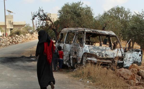A woman walks past a wrecked van near the northwestern Syrian village of Barisha. Local residents and medical staff told NPR that noncombatant civilians who were in the van were injured and killed last year the night of the U.S. raid on the compound of IS A woman walks past a wrecked van near the northwestern Syrian village of Barisha. Local residents and medical staff told NPR that noncombatant civilians who were in the van were injured and killed last year the night of the U.S. raid on the compound of IS