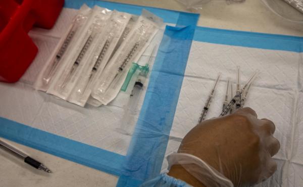 A healthcare worker prepares doses of the Pfizer-BioNTech Covid-19 vaccine at a mobile vaccination clinic at a high school in Los Angeles in August. A healthcare worker prepares doses of the Pfizer-BioNTech Covid-19 vaccine at a mobile vaccination clinic at a high school in Los Angeles in August.