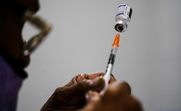 A syringe is prepared with the Pfizer COVID-19 vaccine at a vaccination clinic in Chester, Pa., on Dec. 15, 2021. Pfizer says tweaking its COVID-19 vaccine to better target the omicron variant is safe and boosts protection. A syringe is prepared with the Pfizer COVID-19 vaccine at a vaccination clinic in Chester, Pa., on Dec. 15, 2021. Pfizer says tweaking its COVID-19 vaccine to better target the omicron variant is safe and boosts protection.