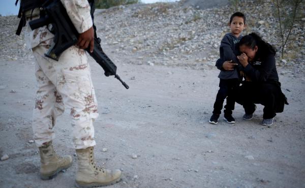 Guatemalan migrant Lety Pérez embraces her son, Anthony, while pleading with a Mexican National Guard member to let them cross into the United States, near Juárez, Mexico, on Monday. Guatemalan migrant Lety Pérez embraces her son, Anthony, while pleading with a Mexican National Guard member to let them cross into the United States, near Juárez, Mexico, on Monday.