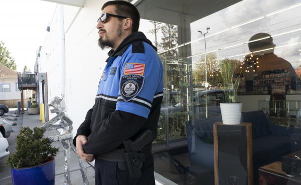 Security guard Austin MacMath wears a gun on his belt while working outside Mary Mart, a marijuana store in Tacoma, Wash., on Tuesday. Security guard Austin MacMath wears a gun on his belt while working outside Mary Mart, a marijuana store in Tacoma, Wash., on Tuesday.