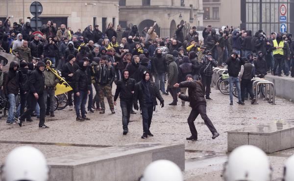 A protester prepares to throw an object at the police during an anti-migrant demonstration outside of European Union headquarters in Brussels on Sunday. A protester prepares to throw an object at the police during an anti-migrant demonstration outside of European Union headquarters in Brussels on Sunday.