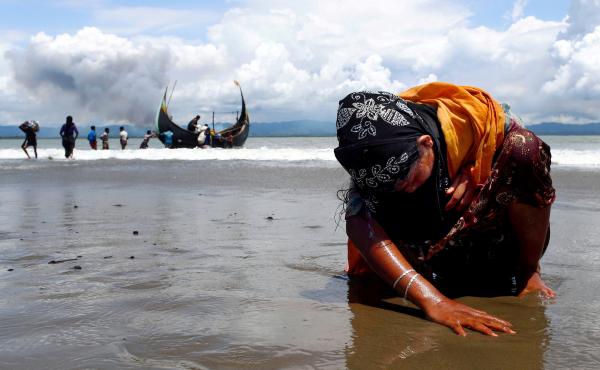 An exhausted Rohingya refugee woman touches the shore after crossing the Bangladesh-Myanmar border by boat through the Bay of Bengal, in Shah Porir Dwip, Bangladesh, on Sept. 11, 2017. An exhausted Rohingya refugee woman touches the shore after crossing the Bangladesh-Myanmar border by boat through the Bay of Bengal, in Shah Porir Dwip, Bangladesh, on Sept. 11, 2017.