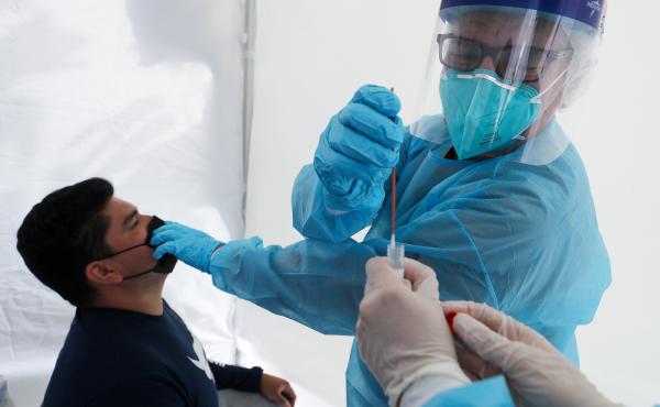 Dr. Glenn Lopez administered a standard test for the coronavirus to Daniel Contreras at a mobile clinic in South Los Angeles last week. Though highly accurate, such tests can take days or more to process. Dr. Glenn Lopez administered a standard test for the coronavirus to Daniel Contreras at a mobile clinic in South Los Angeles last week. Though highly accurate, such tests can take days or more to process.