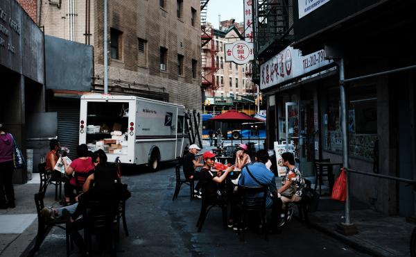 People eat in an outdoor dining area in New York City's Chinatown on Aug. 10. Economists warn spending may suffer this month. People eat in an outdoor dining area in New York City's Chinatown on Aug. 10. Economists warn spending may suffer this month.