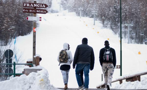 Migrants walk toward a snow-covered pass to cross the border from Italy to France, in January 2018 near Bardonecchia, Italian Alps. Migrants walk toward a snow-covered pass to cross the border from Italy to France, in January 2018 near Bardonecchia, Italian Alps.