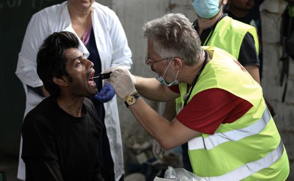 A migrant receives medical attention at a former paper factory in Greece that has been turned into a makeshift camp. A migrant receives medical attention at a former paper factory in Greece that has been turned into a makeshift camp.