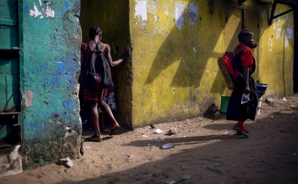 A girl wearing the More Than Me uniform walks into an alley in the West Point neighborhood of Monrovia, Liberia. A girl wearing the More Than Me uniform walks into an alley in the West Point neighborhood of Monrovia, Liberia.