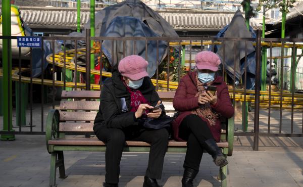Women wearing face masks to protect against COVID-19 look at their smartphones at a public park in Beijing Wednesday. China is reporting a major drop in local COVID-19 infections in the northern city of Xi'an, which has been under a tight lockdown for the Women wearing face masks to protect against COVID-19 look at their smartphones at a public park in Beijing Wednesday. China is reporting a major drop in local COVID-19 infections in the northern city of Xi'an, which has been under a tight lockdown for the