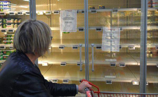A woman reads a sign that says, "Due to a shortage of the raw material to make butter, we are not able to supply and sell you this product," attached to an empty refrigerated supermarket shelf in western France. A woman reads a sign that says, "Due to a shortage of the raw material to make butter, we are not able to supply and sell you this product," attached to an empty refrigerated supermarket shelf in western France.