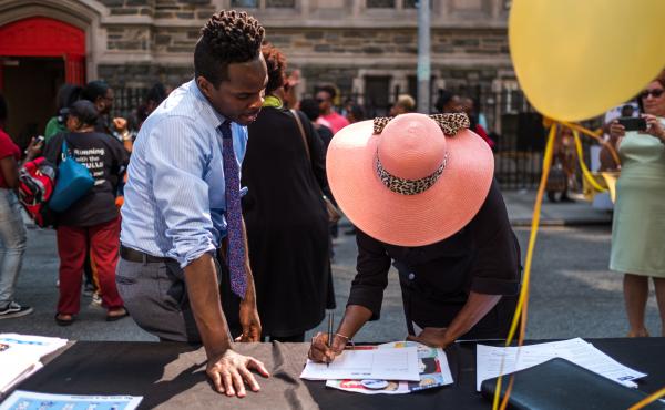 Kolbi Brown (left), a program manager at Harlem Hospital in New York, helps Karen Phillips sign up to receive more information about the All of Us medical research program, during a block party outside the Abyssinian Baptist Church in Harlem. Kolbi Brown (left), a program manager at Harlem Hospital in New York, helps Karen Phillips sign up to receive more information about the All of Us medical research program, during a block party outside the Abyssinian Baptist Church in Harlem.