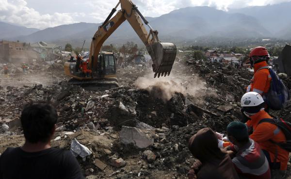 Rescue workers watch as a heavy machine dig through rubble searching for earthquake victims on Thursday in Palu, Central Sulawesi, Indonesia. Rescue workers watch as a heavy machine dig through rubble searching for earthquake victims on Thursday in Palu, Central Sulawesi, Indonesia.