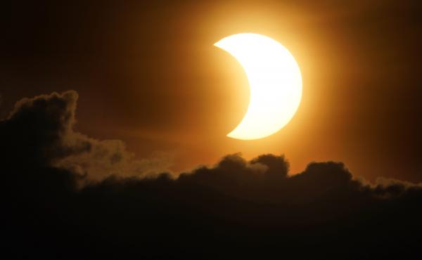 The sun is partially eclipsed as it rises over lower Manhattan in New York on Thursday. The sun is partially eclipsed as it rises over lower Manhattan in New York on Thursday.
