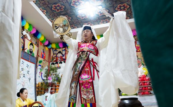 Shaman Jeong Soon-deok holds up a fan, bells and other ceremonial objects during an initiation ceremony at a temple in Seoul. Shaman Jeong Soon-deok holds up a fan, bells and other ceremonial objects during an initiation ceremony at a temple in Seoul.