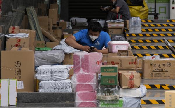 Delivery men sort out their parcels outside a community on Tuesday, May 31, 2022, in Beijing. Delivery men sort out their parcels outside a community on Tuesday, May 31, 2022, in Beijing.