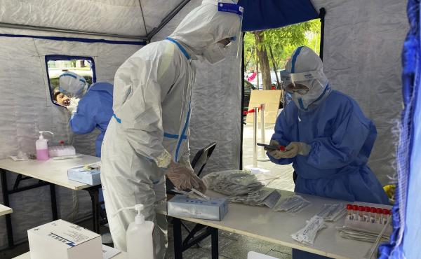 Workers in protective overalls conduct mass COVID testing for residents on May 11, 2022, in Beijing. Workers in protective overalls conduct mass COVID testing for residents on May 11, 2022, in Beijing.