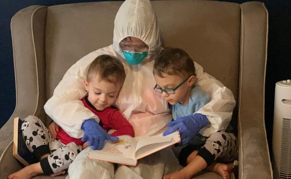 Dr. Lauren Jenkins reads to her twin sons, Pierce and Ashton, while wearing her "hazmat" suit. Because lung cancer has compromised her husband's immune system, Jenkins moved out of her home and visited in the suit as a precaution. Dr. Lauren Jenkins reads to her twin sons, Pierce and Ashton, while wearing her "hazmat" suit. Because lung cancer has compromised her husband's immune system, Jenkins moved out of her home and visited in the suit as a precaution.