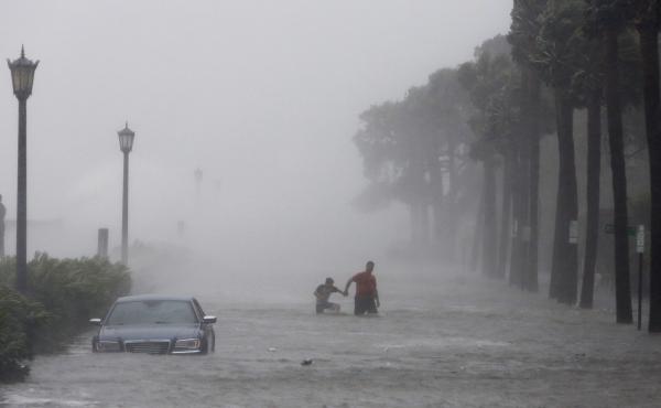 Pedestrians walk on a flooded street on Sept. 11 as tropical storm Irma hits Charleston, S.C. Pedestrians walk on a flooded street on Sept. 11 as tropical storm Irma hits Charleston, S.C.