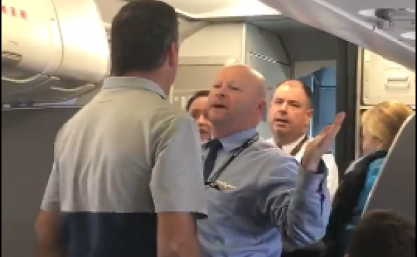 A passenger and an American Airlines employee stand face-to-face in a video captured by another passenger on an American Airlines flight, Friday. A passenger and an American Airlines employee stand face-to-face in a video captured by another passenger on an American Airlines flight, Friday.