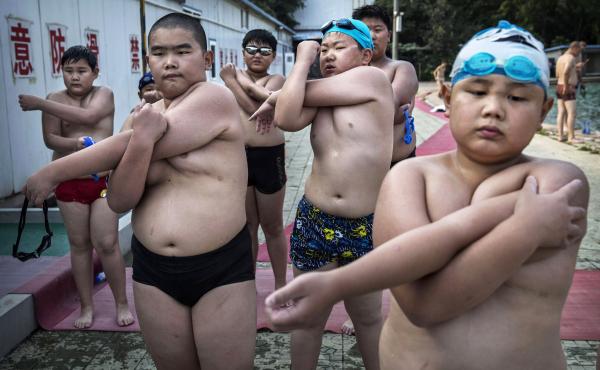At a camp for overweight children in Beijing, students stretch after taking a swim. At a camp for overweight children in Beijing, students stretch after taking a swim.