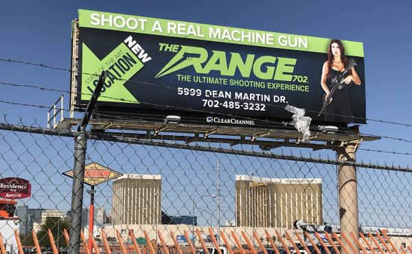 A billboard advertising a gun tourism business in Las Vegas hovers above the Mandalay Bay Hotel, site of a mass shooting Sunday night that killed 58 people and injured nearly 500. A billboard advertising a gun tourism business in Las Vegas hovers above the Mandalay Bay Hotel, site of a mass shooting Sunday night that killed 58 people and injured nearly 500.