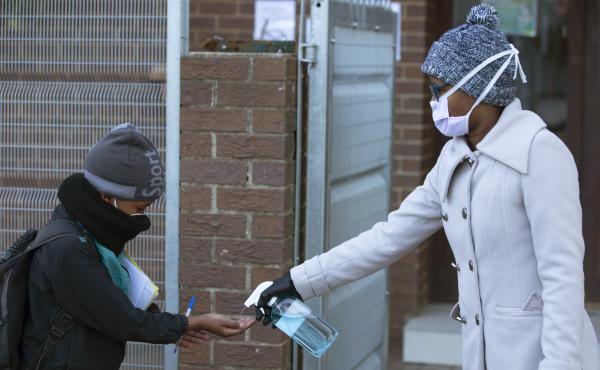 A pupil receives hand sanitizer upon returning to school in Johannesburg on July 6. Since easing its lockdown, coronavirus cases have spiked and the government is introducing some restrictions. A pupil receives hand sanitizer upon returning to school in Johannesburg on July 6. Since easing its lockdown, coronavirus cases have spiked and the government is introducing some restrictions.