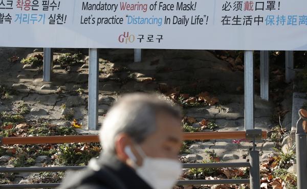 A man wearing a face mask walks past a banner showing precautions against the coronavirus in Seoul on Monday. A man wearing a face mask walks past a banner showing precautions against the coronavirus in Seoul on Monday.
