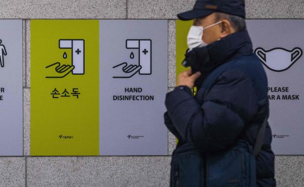 A commuter walks past information boards displayed to remind the public about how to help prevent the spread of the coronavirus in Seoul on Wednesday. A commuter walks past information boards displayed to remind the public about how to help prevent the spread of the coronavirus in Seoul on Wednesday.