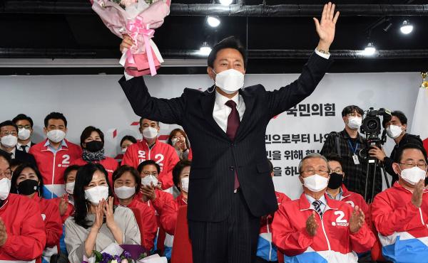 Oh Se-hoon (center), the mayoral candidate of the main opposition People Power Party, holds flowers as he celebrates with party members after exit polls showed he would win. Oh Se-hoon (center), the mayoral candidate of the main opposition People Power Party, holds flowers as he celebrates with party members after exit polls showed he would win.