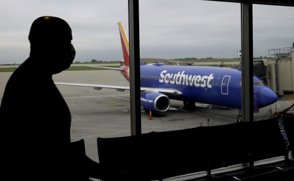 A man wearing a mask prepares to board a Southwest Airlines flight at Kansas City International airport in Kansas City, Mo. Southwest and American Airlines are tightening their mask requirements at the end of July by doing away with exemptions for travele A man wearing a mask prepares to board a Southwest Airlines flight at Kansas City International airport in Kansas City, Mo. Southwest and American Airlines are tightening their mask requirements at the end of July by doing away with exemptions for travele